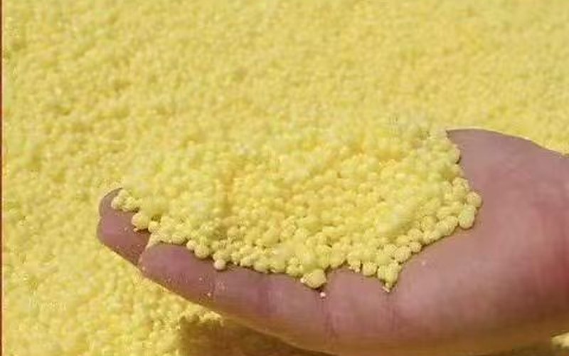Sulphur granules held in hand — quality close-up